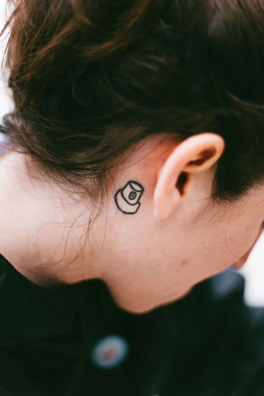 photo of tattoo near person s ear